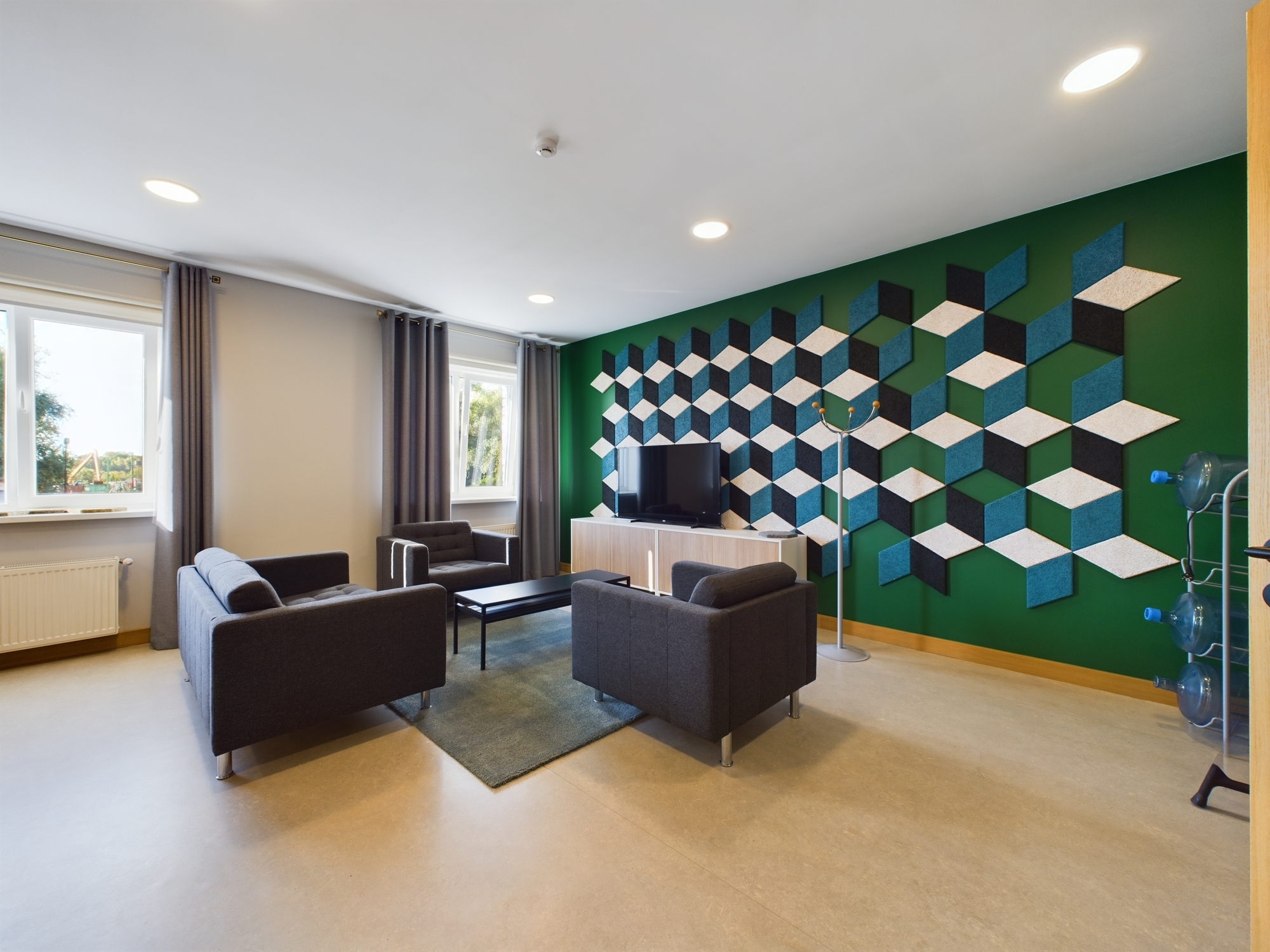 Moderna biroja atpūtas telpa ar 3D kubu sienas apdari un tumšām mēbelēm. Kvalitatīva komercplatību fotogrāfija Rīgā.