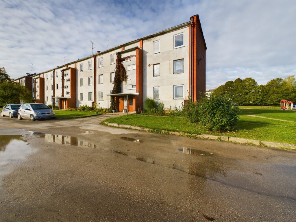 Siltinātas, renovētas daudzdzīvokļu mājas fasāde. Kvalitatīva dzīvokļu pārdošanas fotogrāfija.