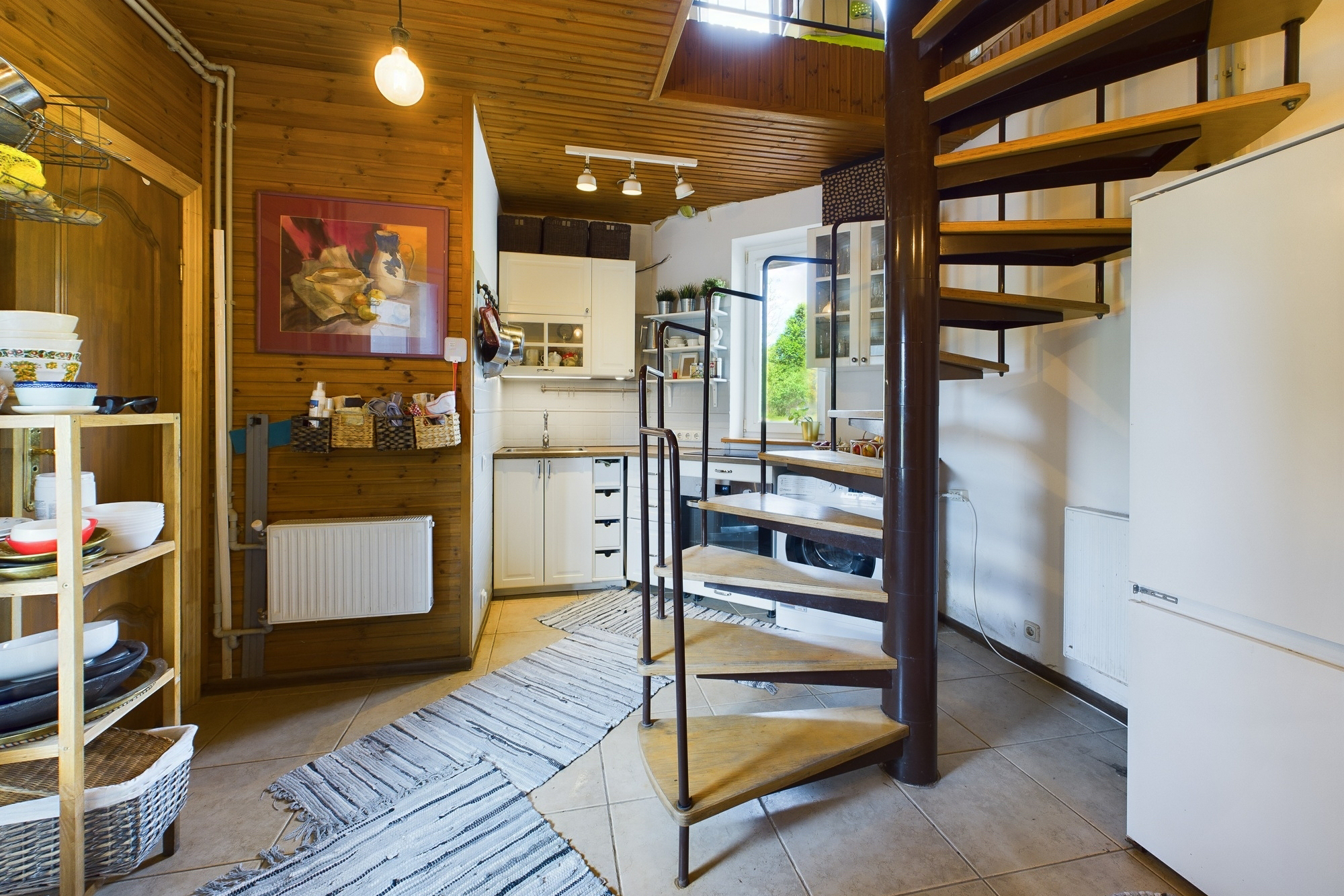 Funkcionāls interjers ar spirālveida kāpnēm un virtuves zonu. Kvalitatīvas telpu fotogrāfijas pārdošanai.