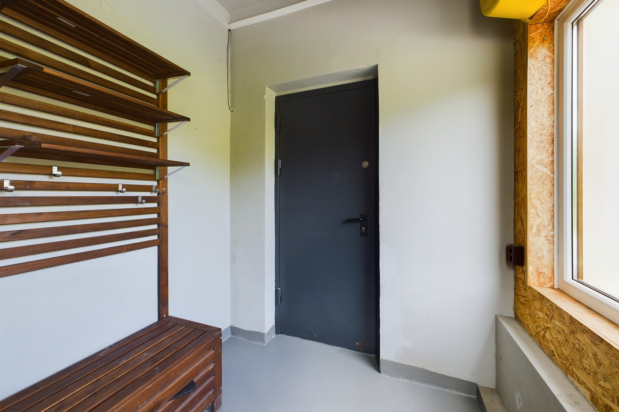 Priekšnams ar mūsdienīgu koka soliņu un plauktiem. Kvalitatīvas interjera fotogrāfijas dzīvokļa pārdošanai.