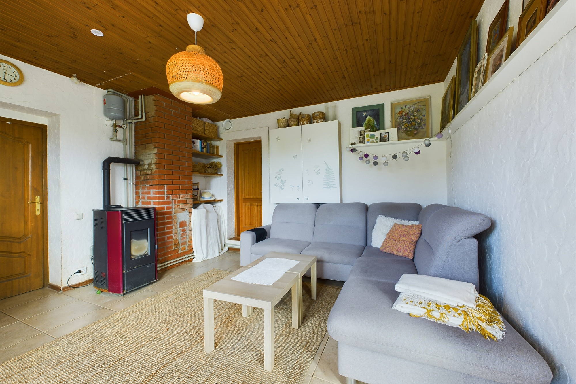 Kvalitatīvs interjera kadrs. Viesistaba ar krāsni un mīkstajām mēbelēm nekustamā īpašuma pārdošanai.