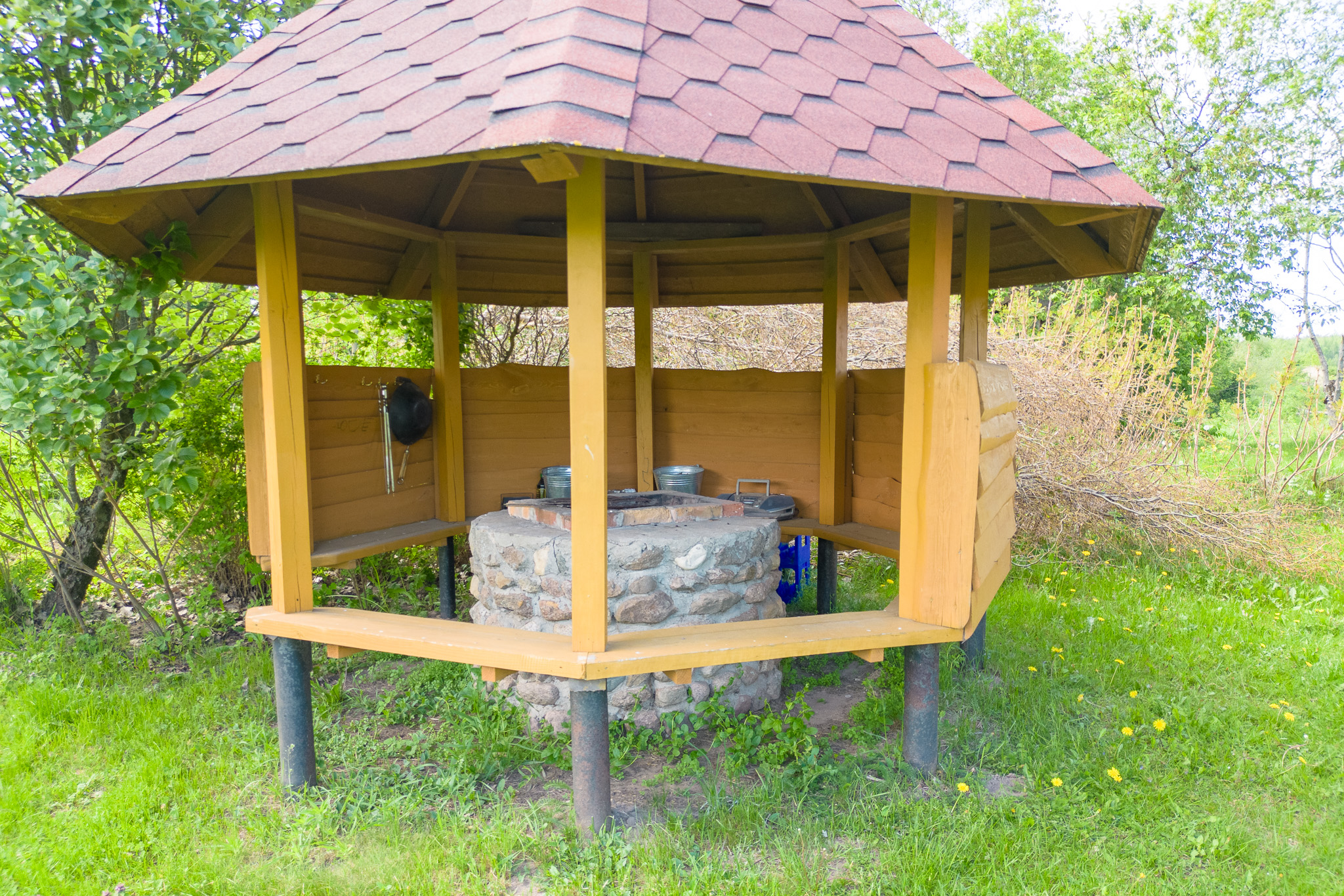 Detalizēta labiekārtojuma fotogrāfija. Koka lapene ar akas imitāciju nekustamā īpašuma pārdošanai.