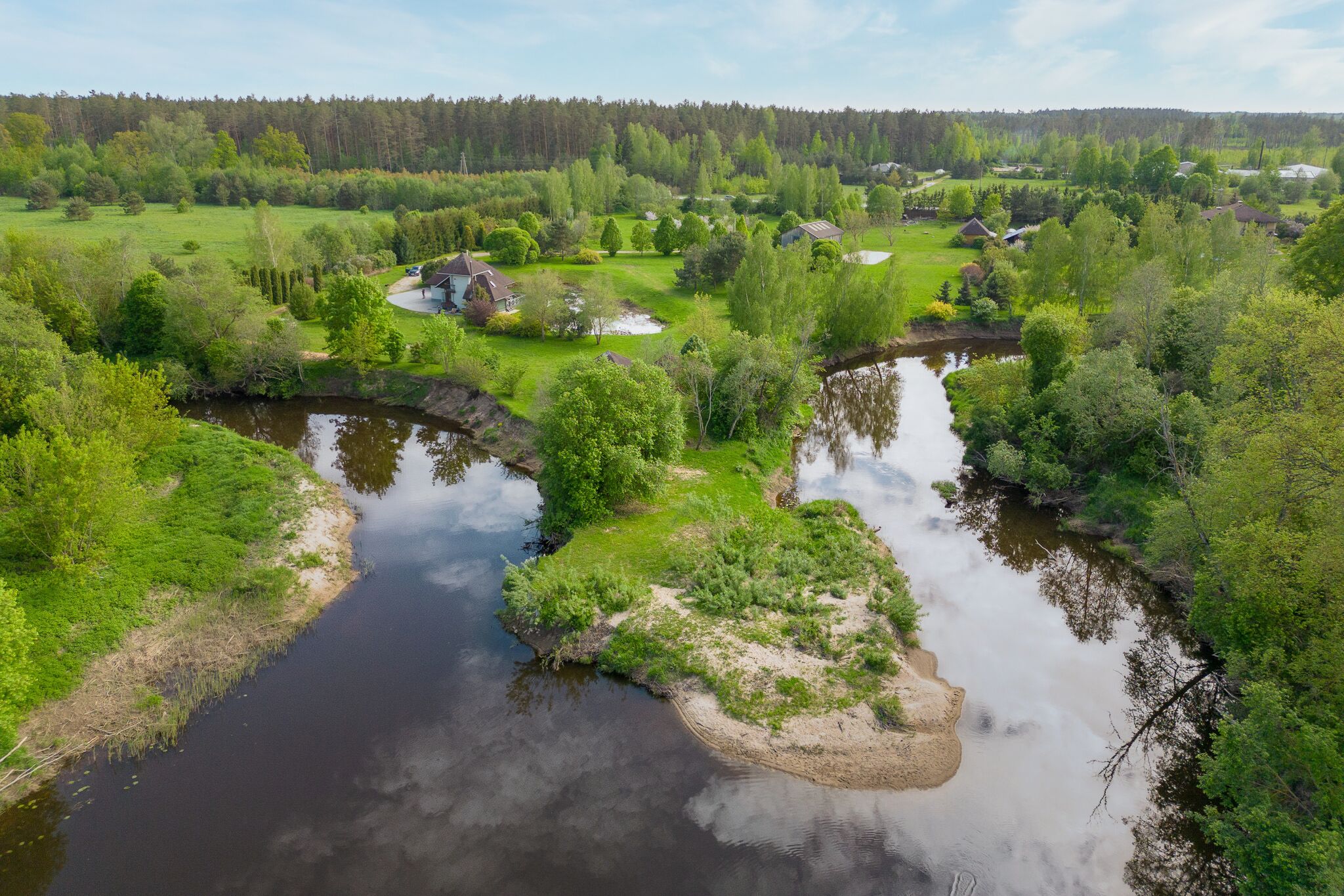 Kvalitatīva nekustamā īpašuma fotogrāfija ar dronu: Ainavisks skats uz upi un mežu – drona video
