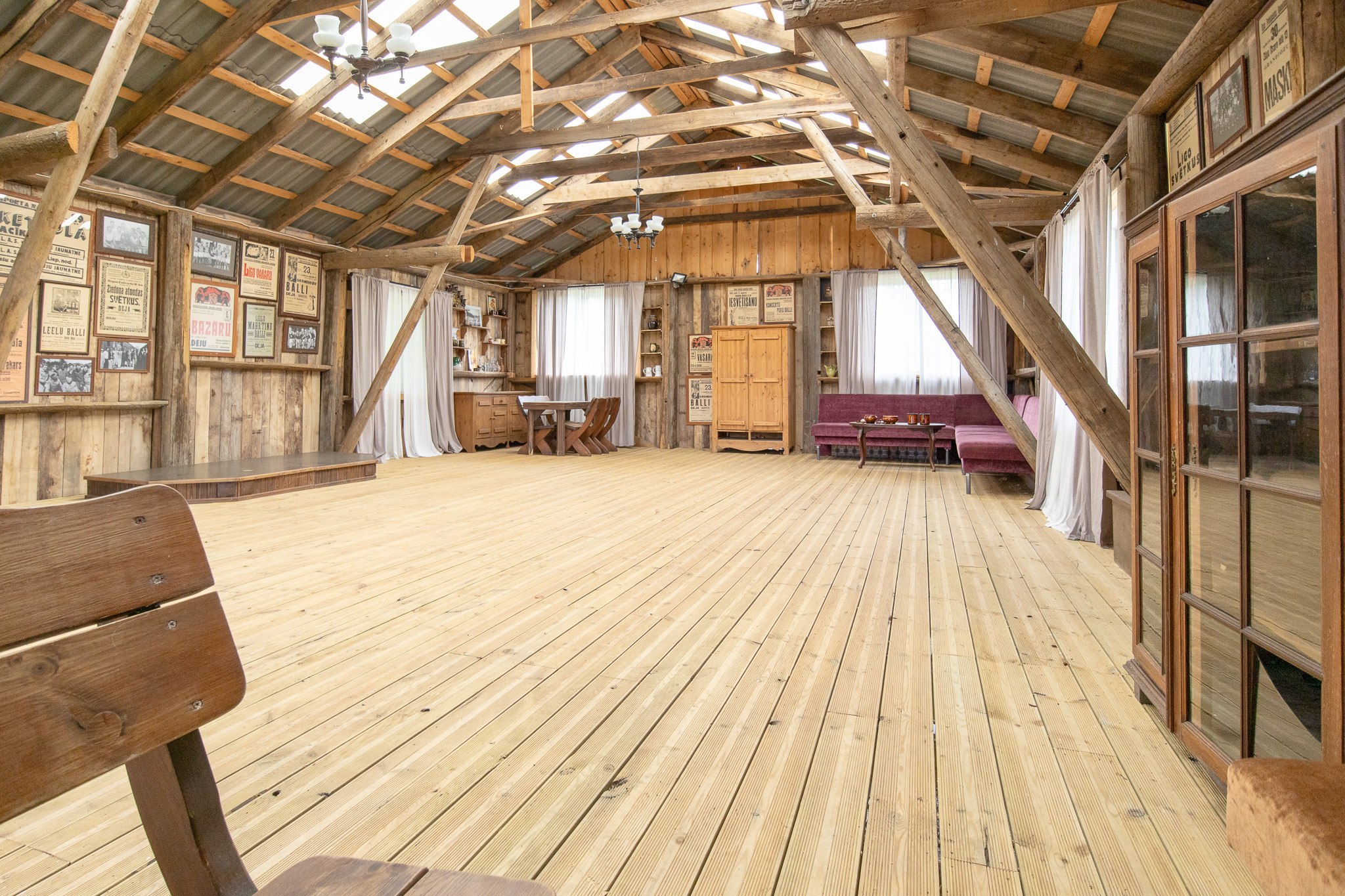 Interjera fotogrāfija. Atklātas koka sijas un dēļu grīda. Unikālas nekustamā īpašuma telpas Latvijā.
