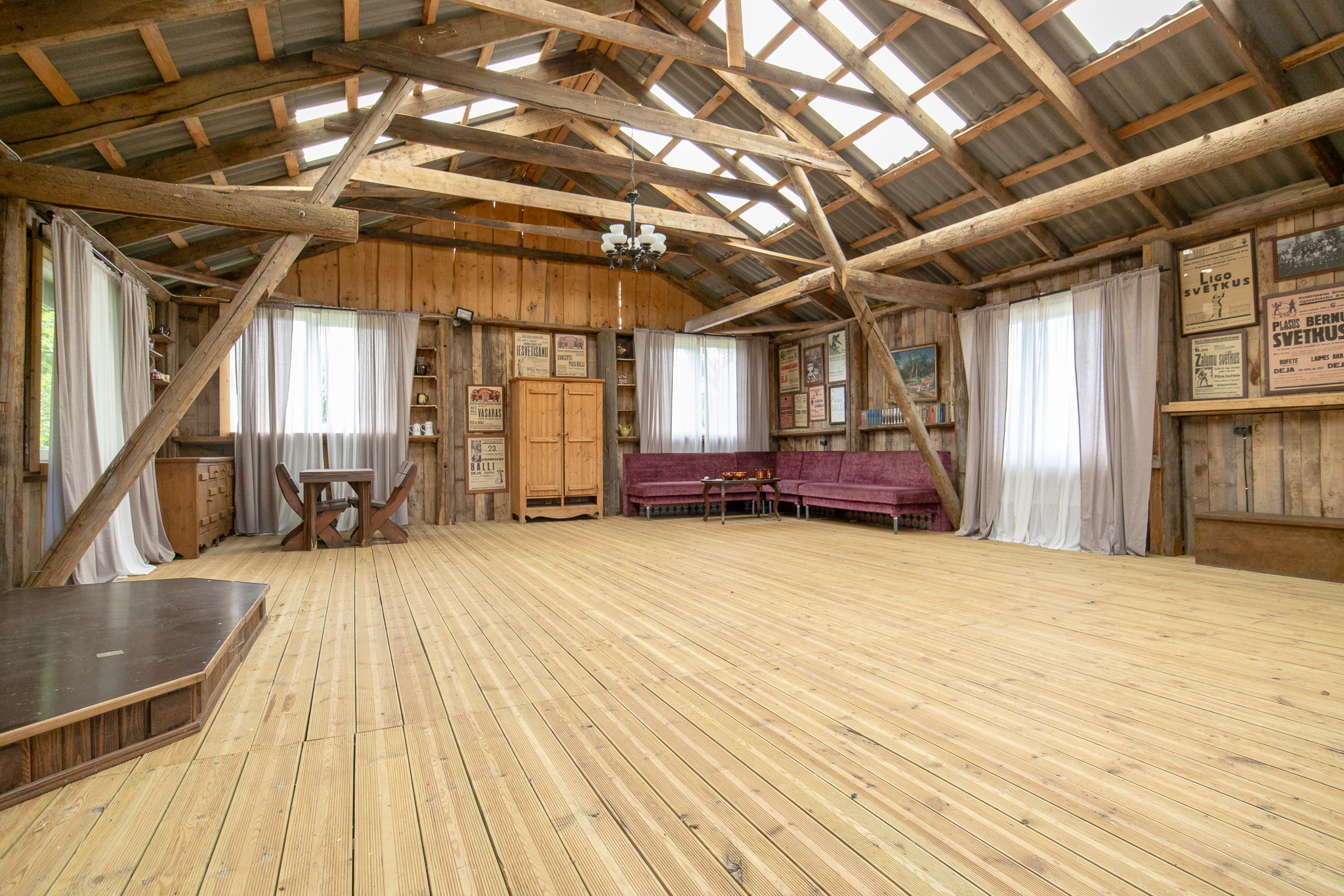 Rustikālas telpas interjera fotogrāfija ar koka sijām – īpašumu izīrēšana