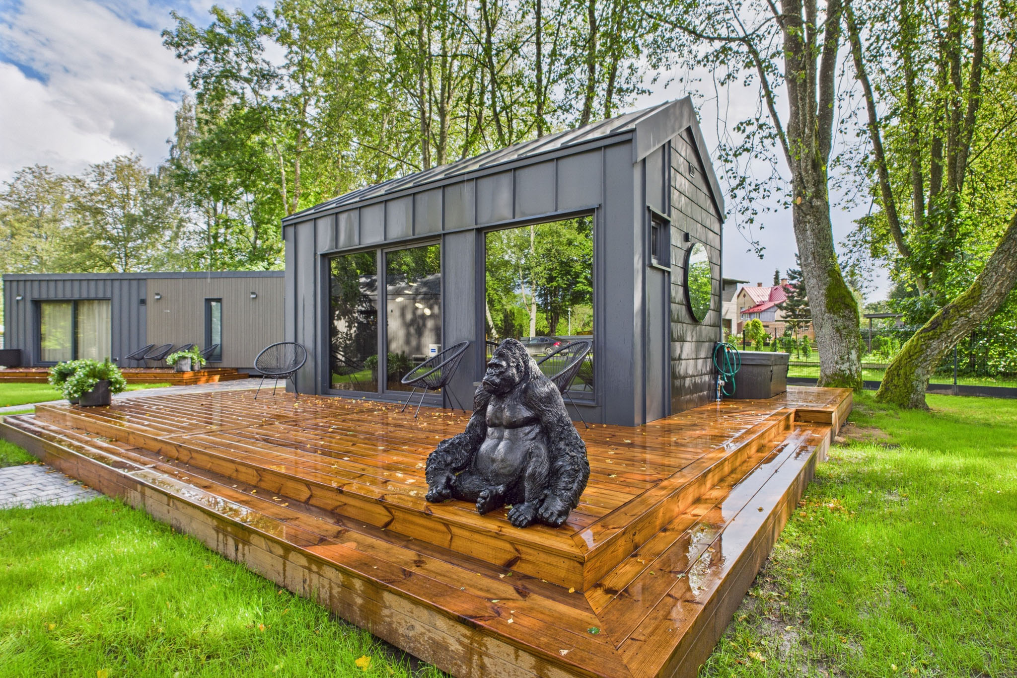 Mūsdienīgs dārza interjers: Stiklota lapene uz koka terases – drona fotogrāfijas un foto