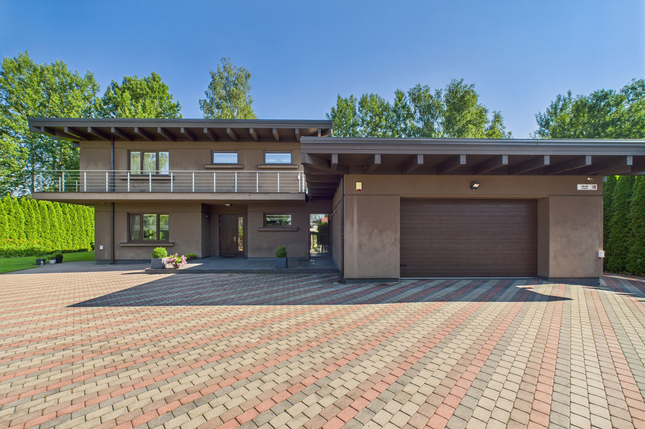 Kvalitatīva mājas fotogrāfija: Mūsdienīga privātmāja ar plakanu jumtu un garāžu