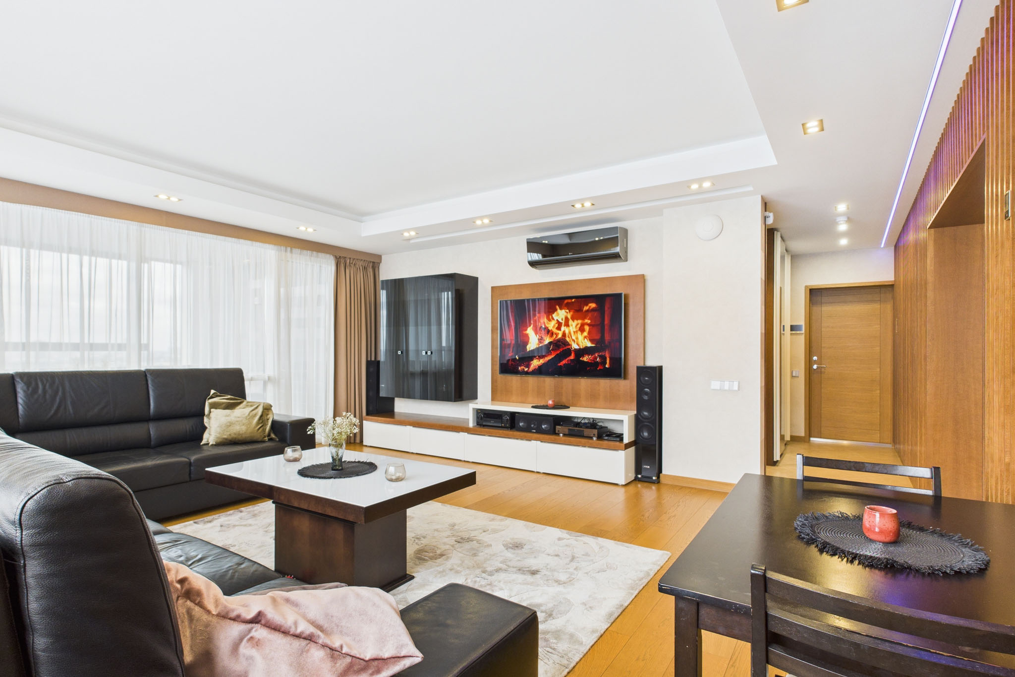 Funkcionāls dzīvokļa interjers: Viesistaba ar ēdamzonu un mediju centru – nekustamā īpašuma fotogrāfijas