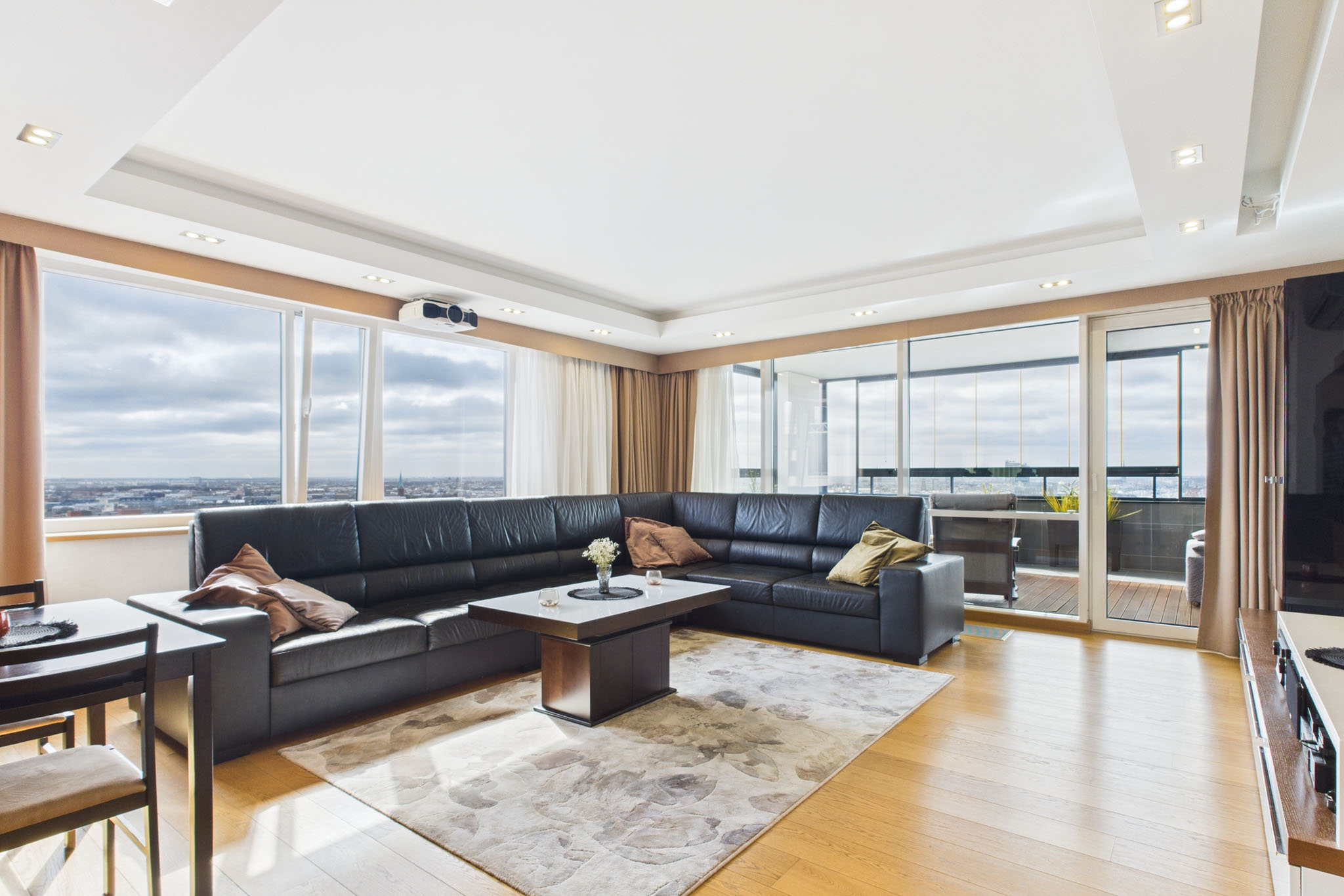 Mūsdienīgs dzīvokļa interjers: Viesistaba ar tumšām mēbelēm un skatu no logiem – nekustamā īpašuma fotogrāfijas
