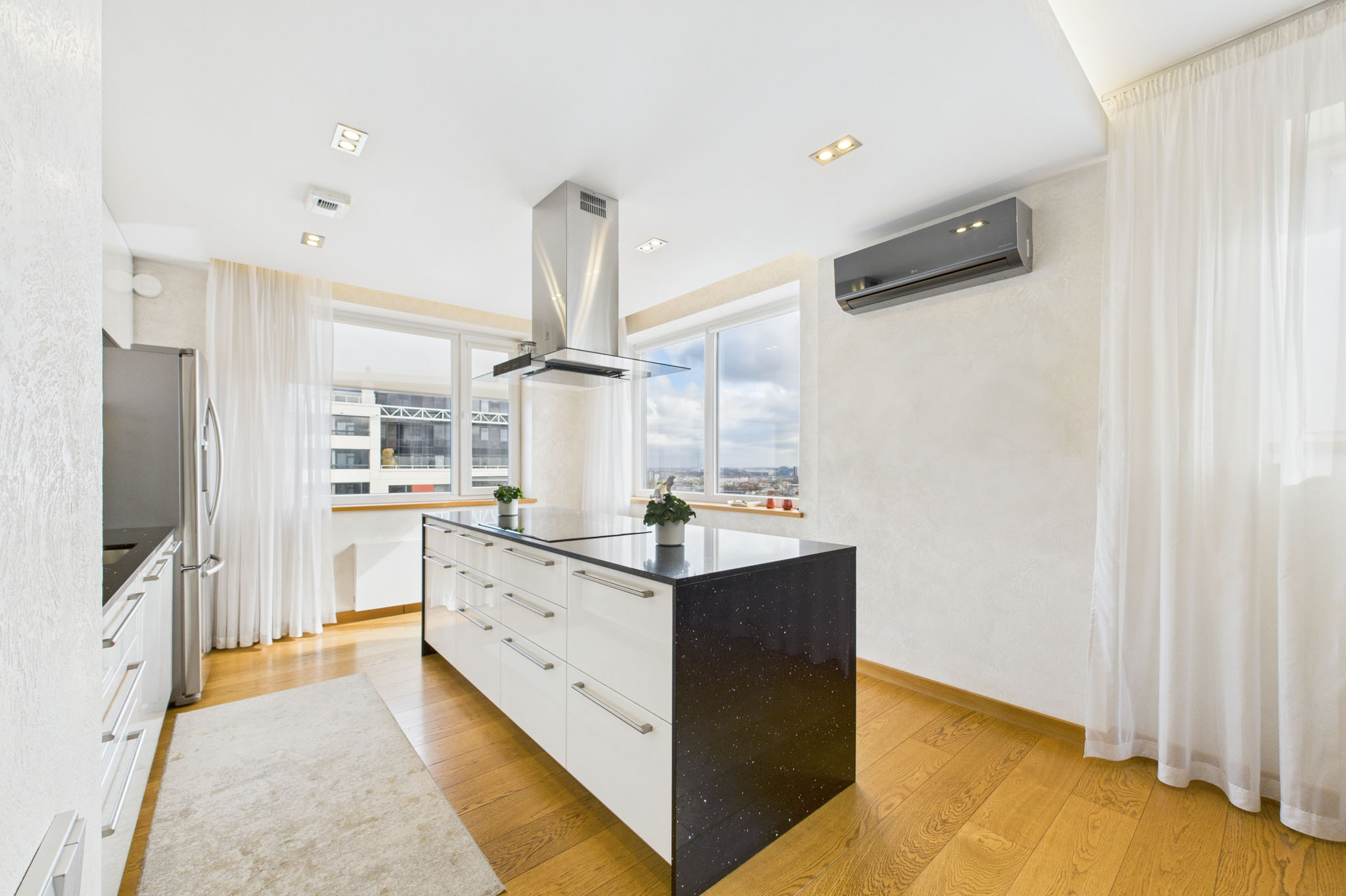 Funkcionāls dzīvokļa interjers: Minimālisma virtuve ar salas galdu un pilsētas skatu – nekustamā īpašuma fotogrāfijas