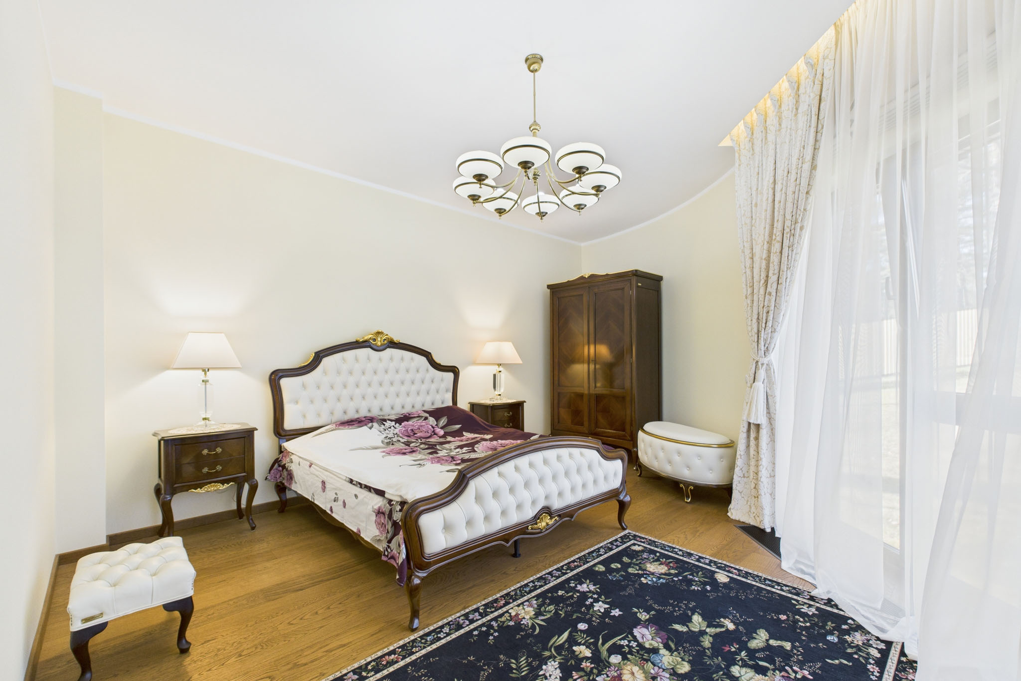 Eleganta dzīvokļa interjers: Klasiska guļamistaba ar dabisku gaismu un lustru – nekustamā īpašuma fotogrāfijas