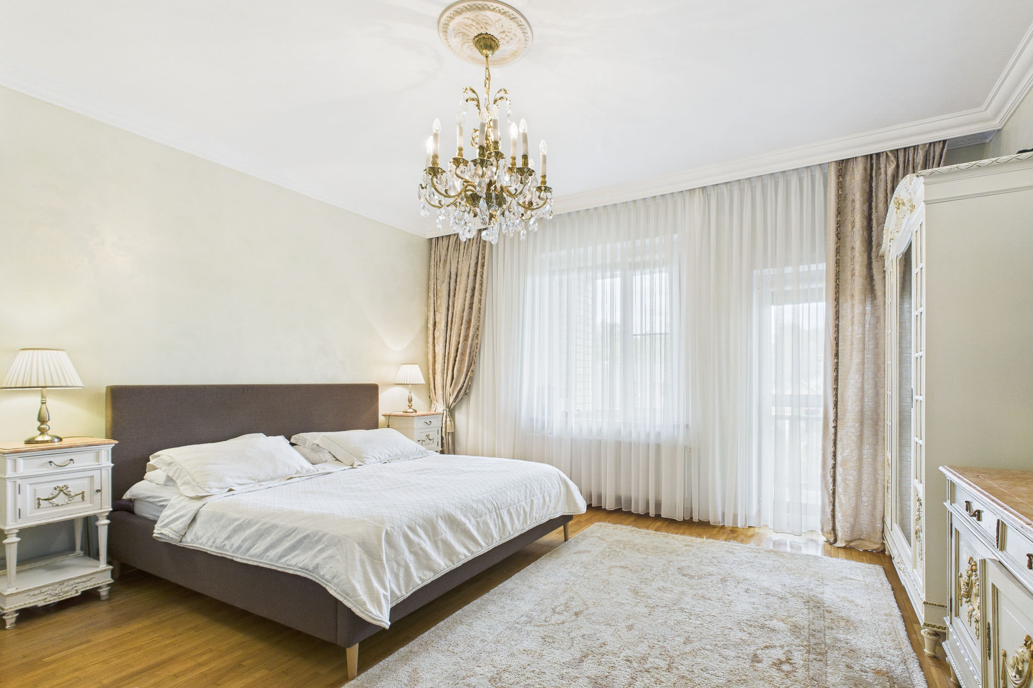 Kvalitatīva interjera fotogrāfija: Grezna guļamistaba ar lustru – nekustamā īpašuma fotogrāfijas