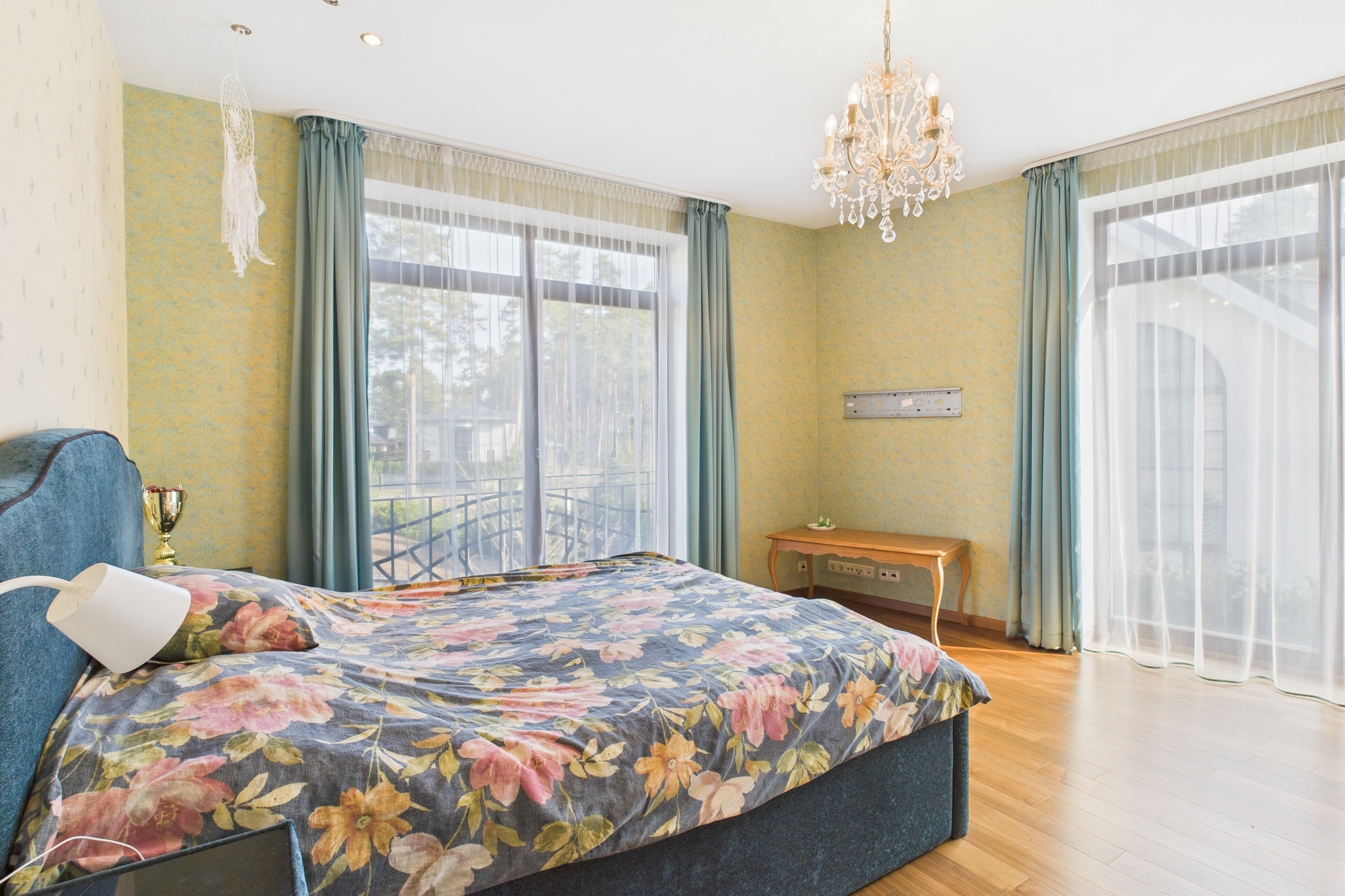 Kvalitatīva interjera fotogrāfija: Klasiska guļamistaba ar kristāla lustru un plašiem logiem – nekustamā īpašuma fotogrāfijas