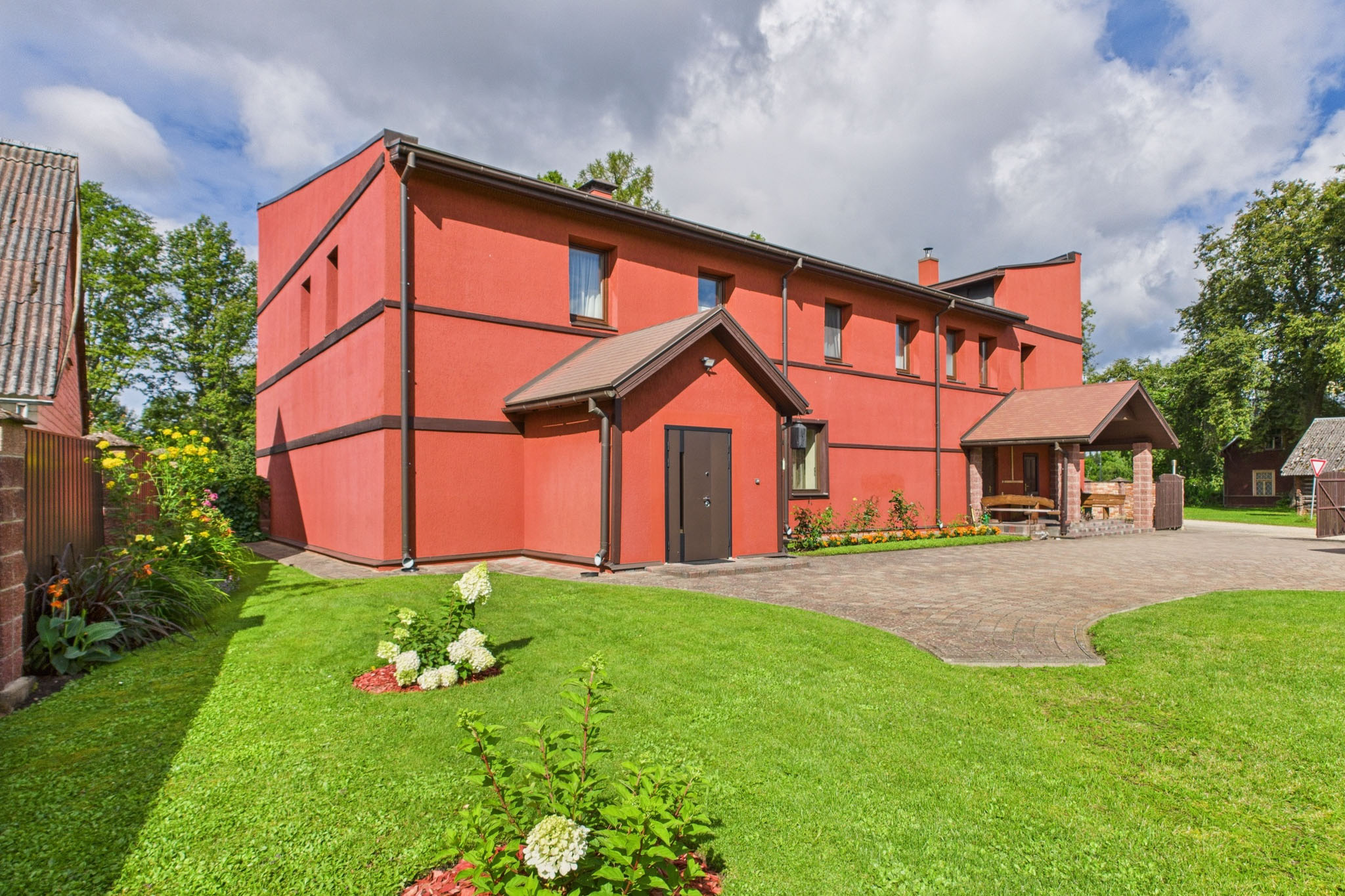 Kvalitatīva mājas fotogrāfija: Privātmāja ar sarkanu fasādi un zālienu – drona fotogrāfijas un foto