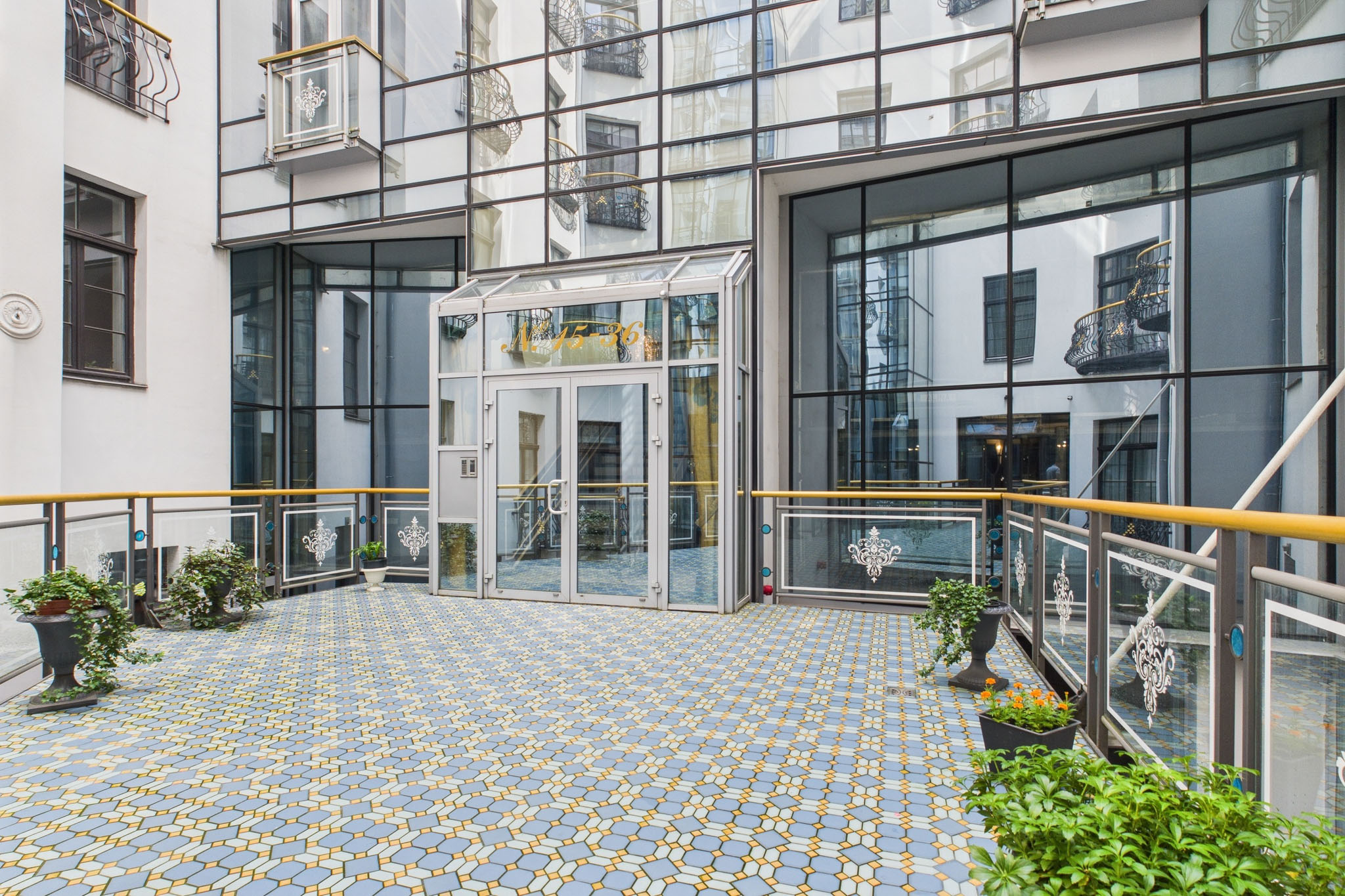 Kvalitatīva ēkas fasādes fotogrāfija: Moderna ieejas zona jaunajam dzīvokļu projektam Rīga